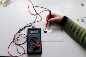 Look, look, look! I used a voltmeter to see if the battery generated current. The positive end is touching the zinc, the negative the aluminum foil. It worked!